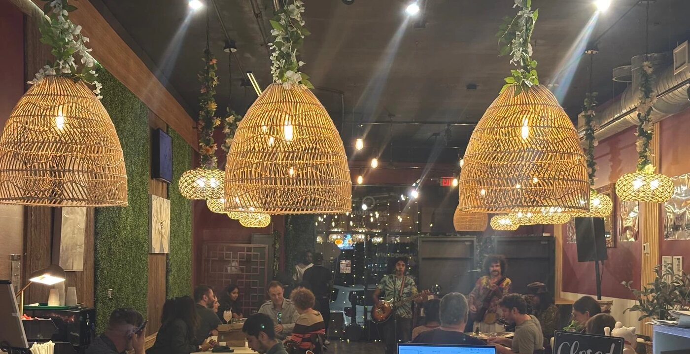 The cafe on a music night, with woven pendant lanterns and guests at tables