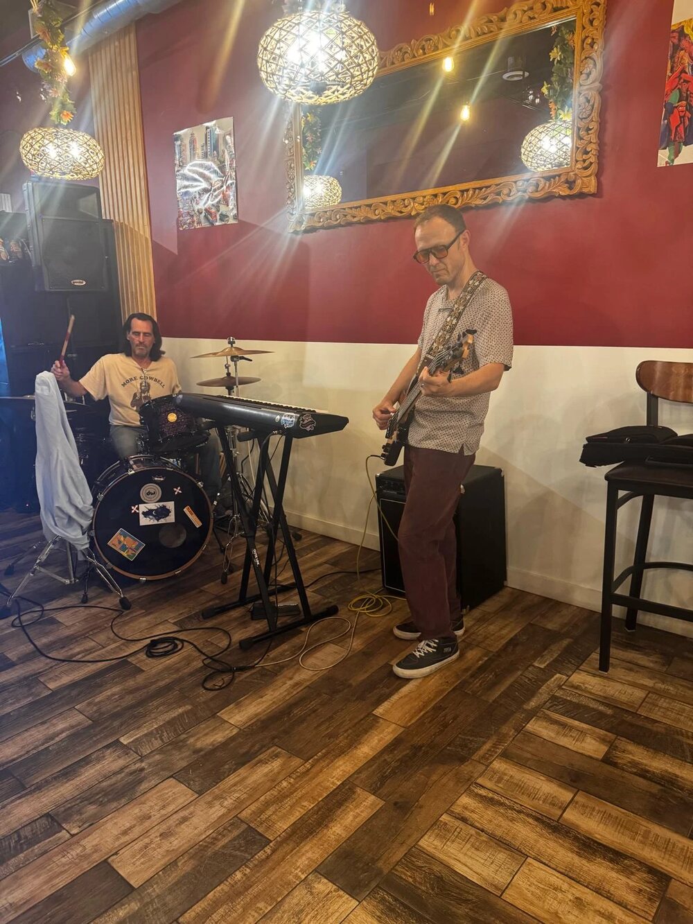 Musicians playing in the cafe beside the carved mirror and red wall