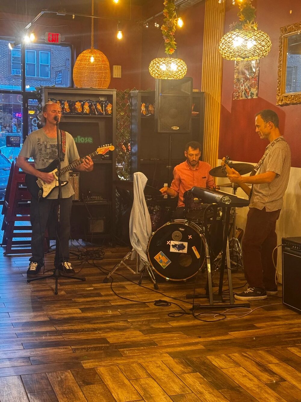 A trio performing in front of the cafe's front windows